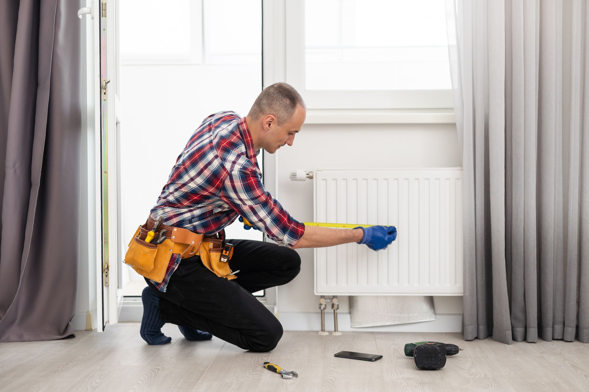 A man is working on a heating panel. A man is working on a heating panel.