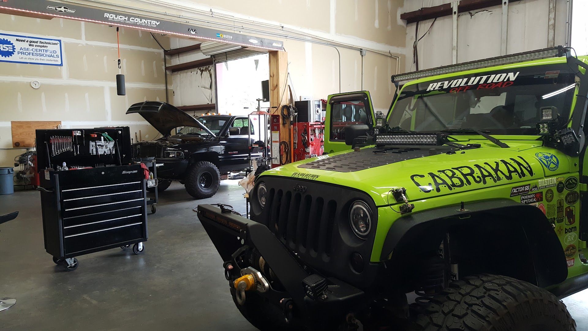 Custom Green Jeep Wrangler Inside Performance Auto Shop in Kennesaw, GA | Revolution Auto Service