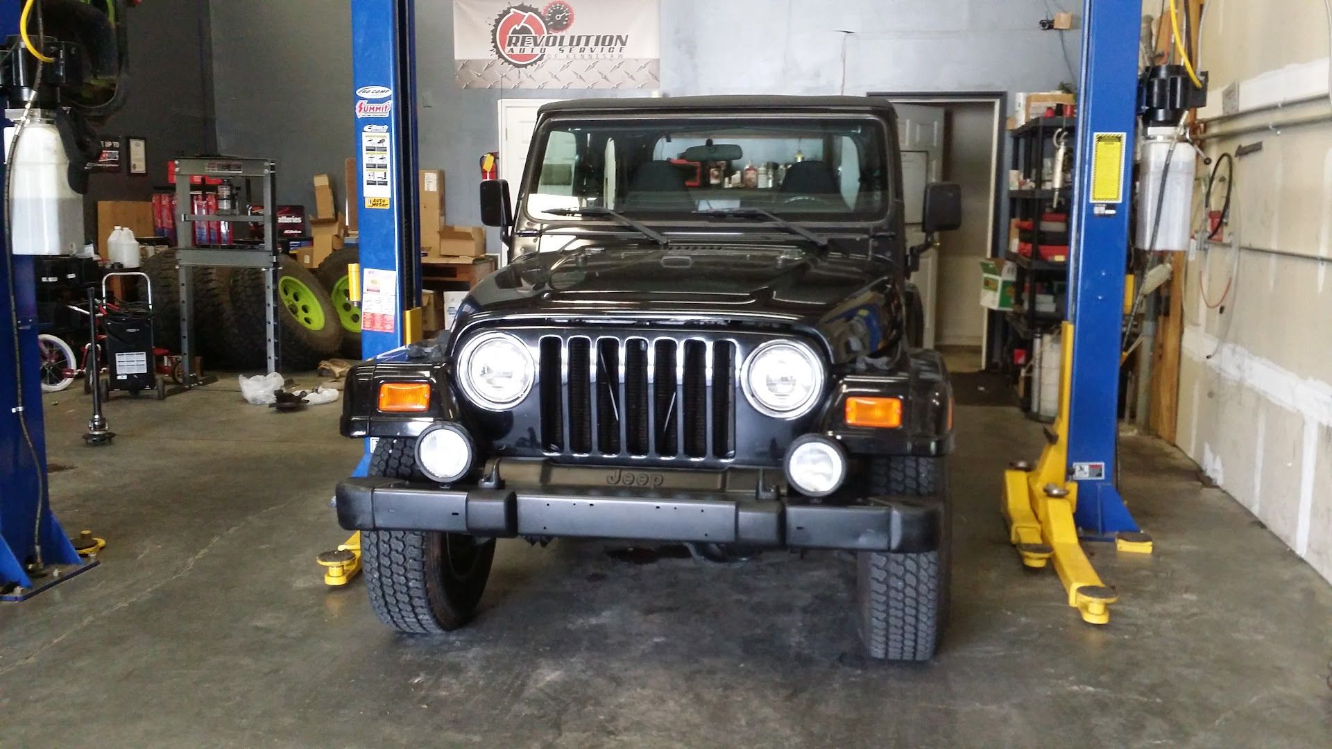 Black Jeep Wrangler Inside Auto Repair Shop Bay in Kennesaw, GA | Revolution Auto Service