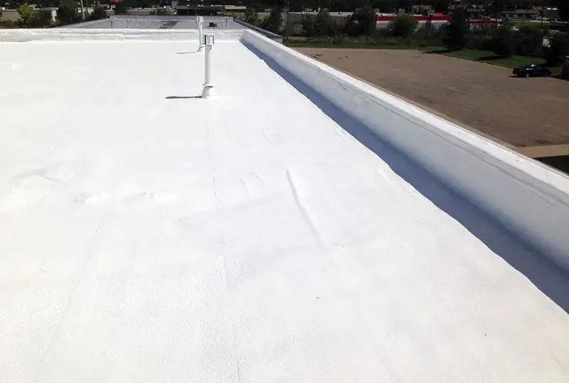 A white roof with a drain on the side of it.