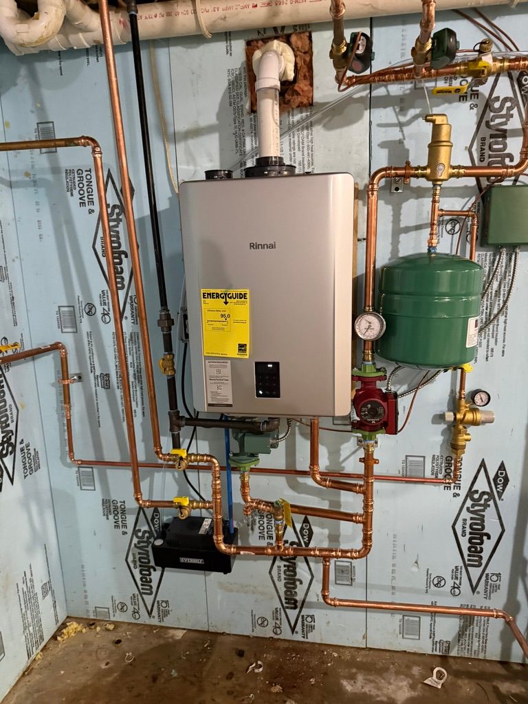 Wall-mounted boiler and copper piping in a utility room, with green expansion tank and gauges