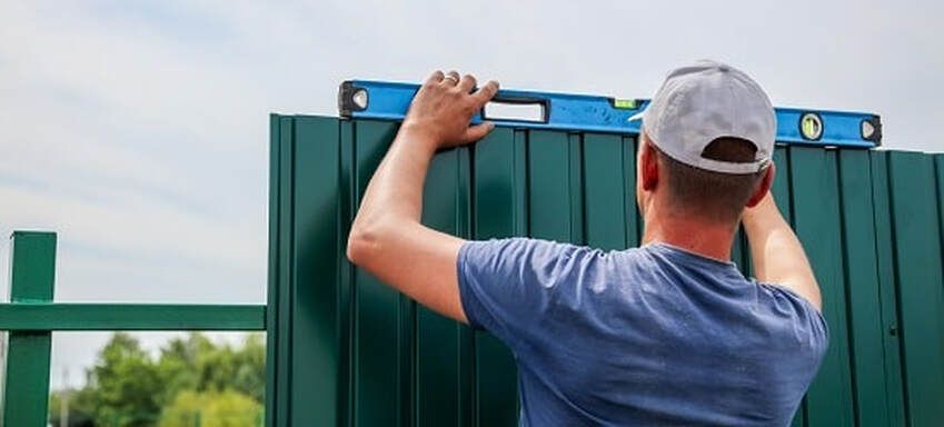 A fencing contractor leveling the colorbond fencing in a property in Ballarat VIC.