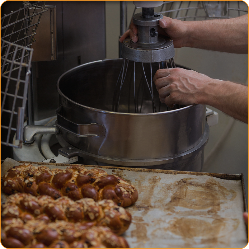 A person is mixing something in a mixer in a kitchen