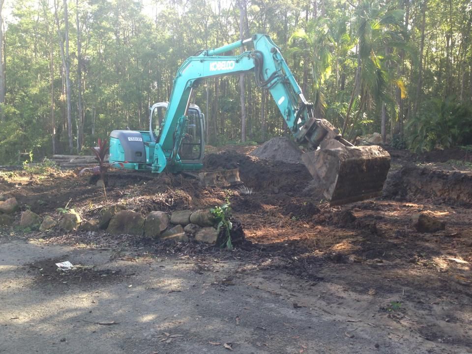 A Blue Excavator is Digging a Hole in the Dirt — Al's Excavation in Bridges, QLD