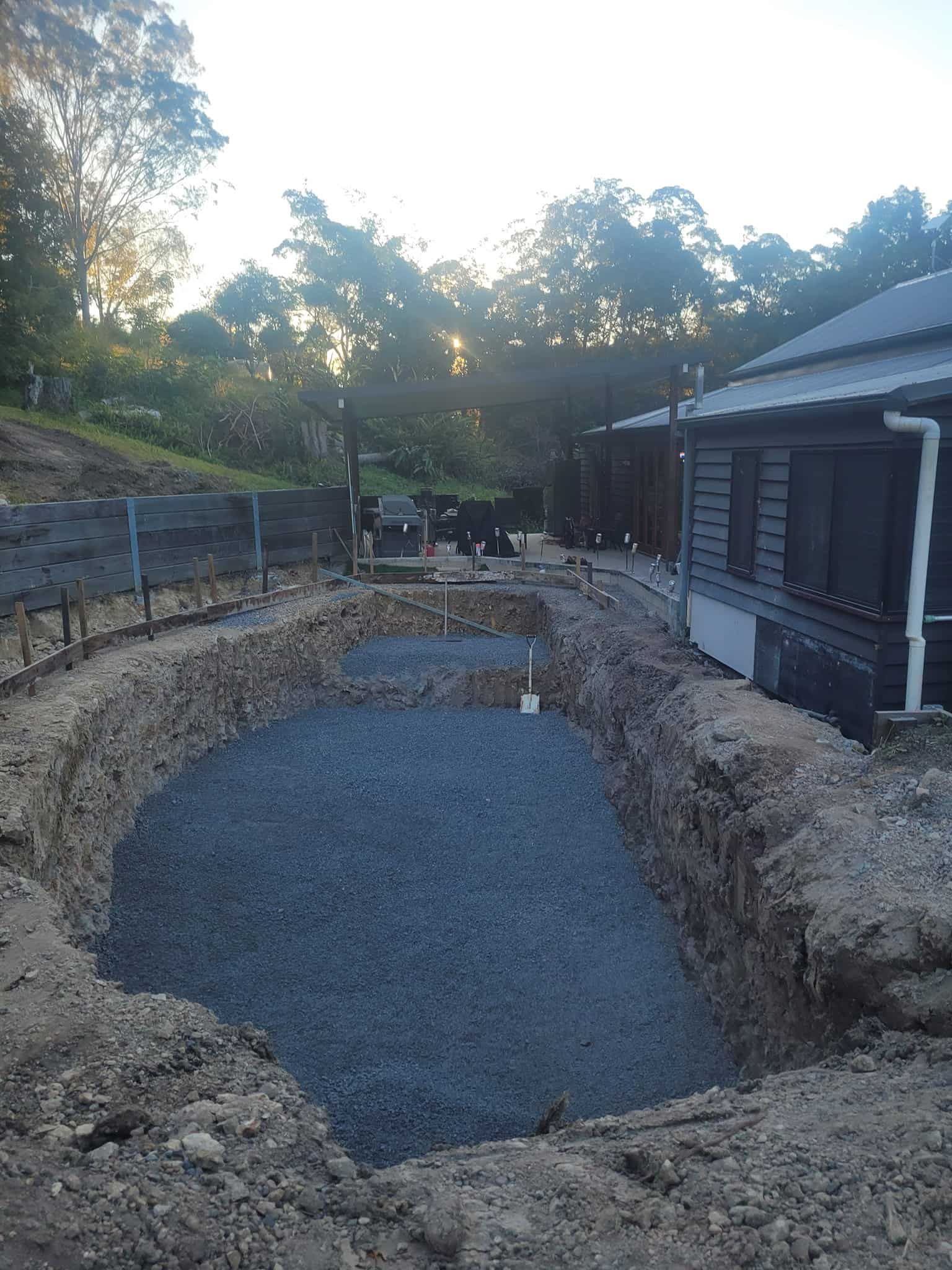 A large hole in the ground in front of a house. — Al's Excavation in Bridges, QLD