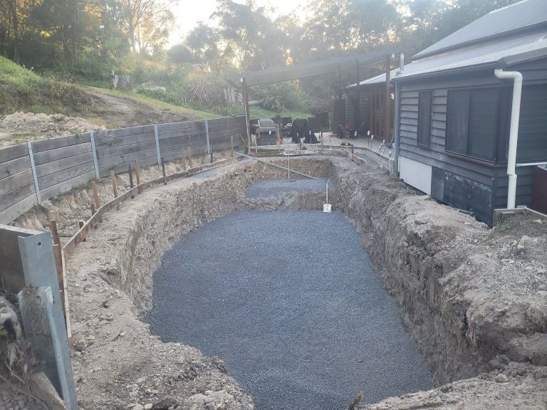 A Large Hole in the Ground in Front of a House — Al's Excavation in Bridges, QLD