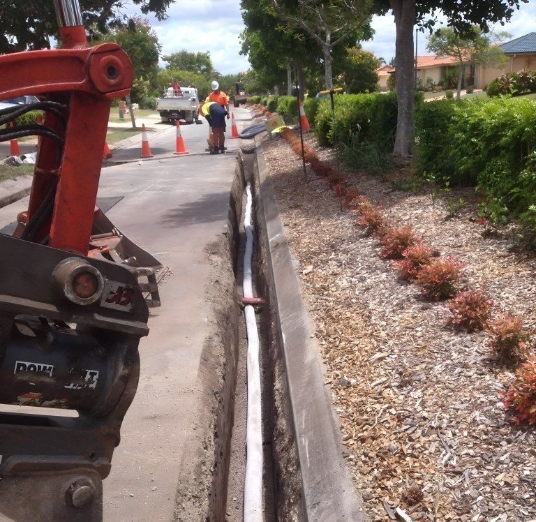 A Man is Walking Down a Sidewalk Next to a Machine That Says Dave on It — Al's Excavation in Bridges, QLD