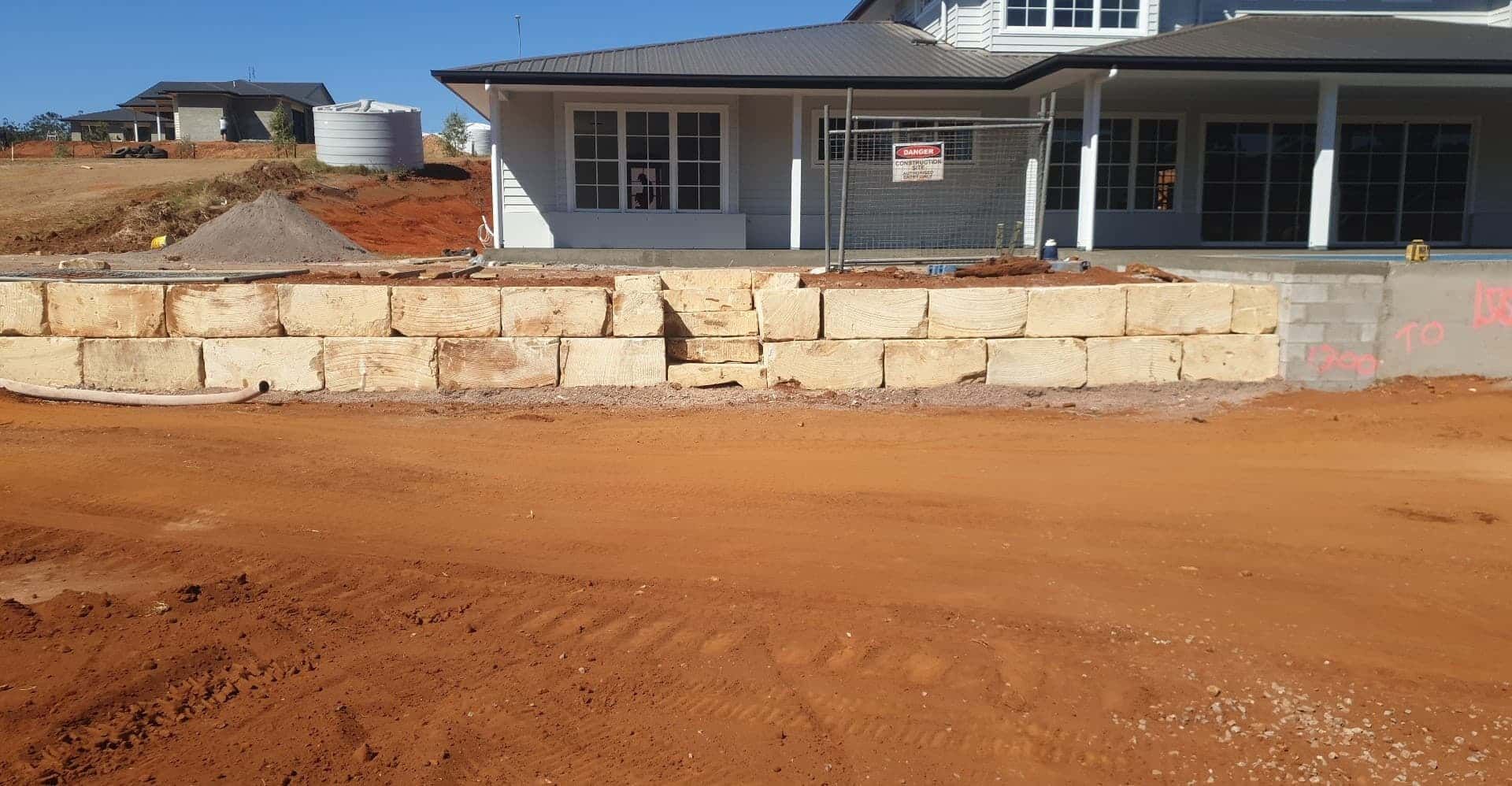A large brick wall is being built in front of a house. — Al's Excavation in Sunshine Coast, QLD