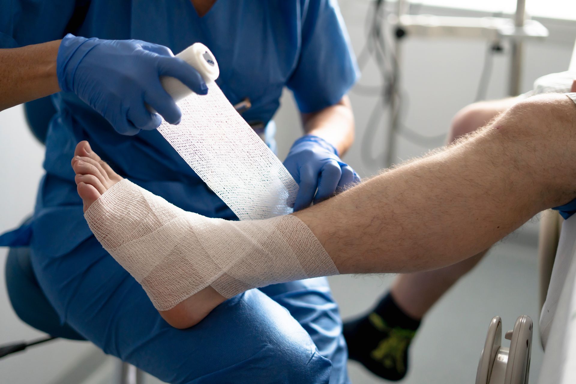 Nurse wrapping bandage around injured foot