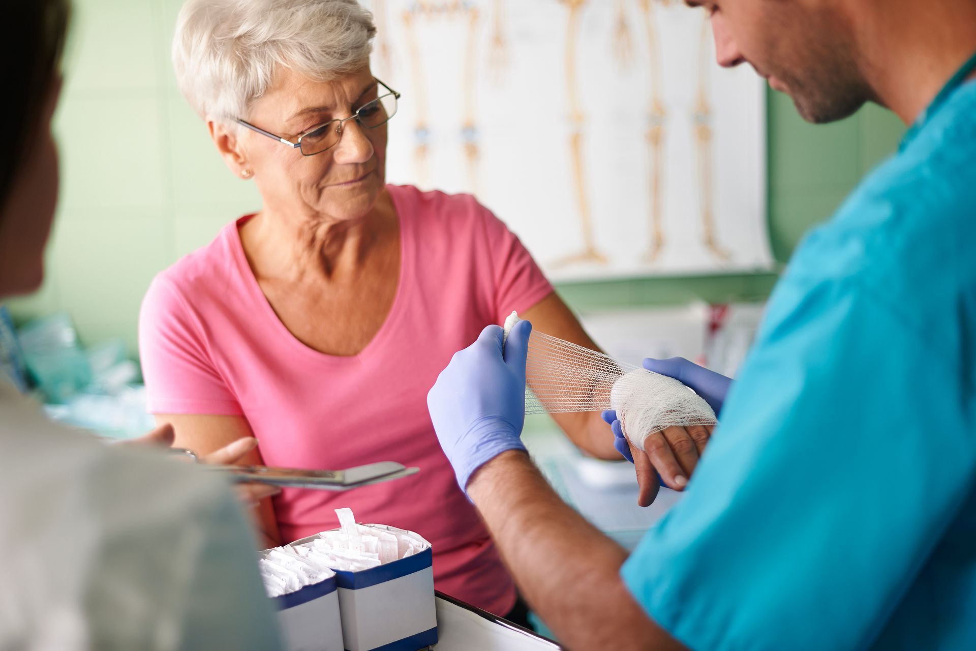 Nurse wrapping elderly woman's hand