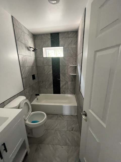 A bathroom with a toilet , sink , bathtub and shower.