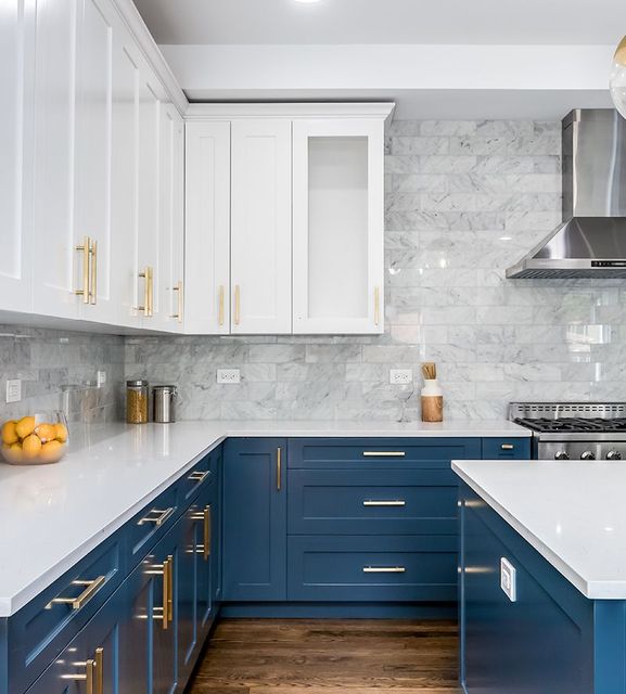 A kitchen with blue cabinets and white counter tops