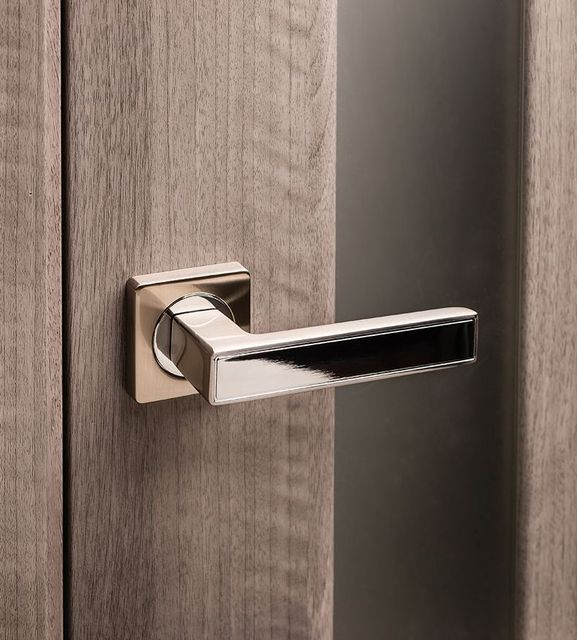 A close up of a door handle on a wooden door.