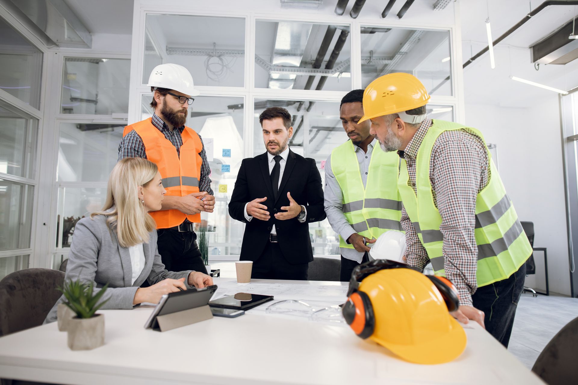 Group Of People Reviewing Plans In Office Group Of People Reviewing Plans In Office