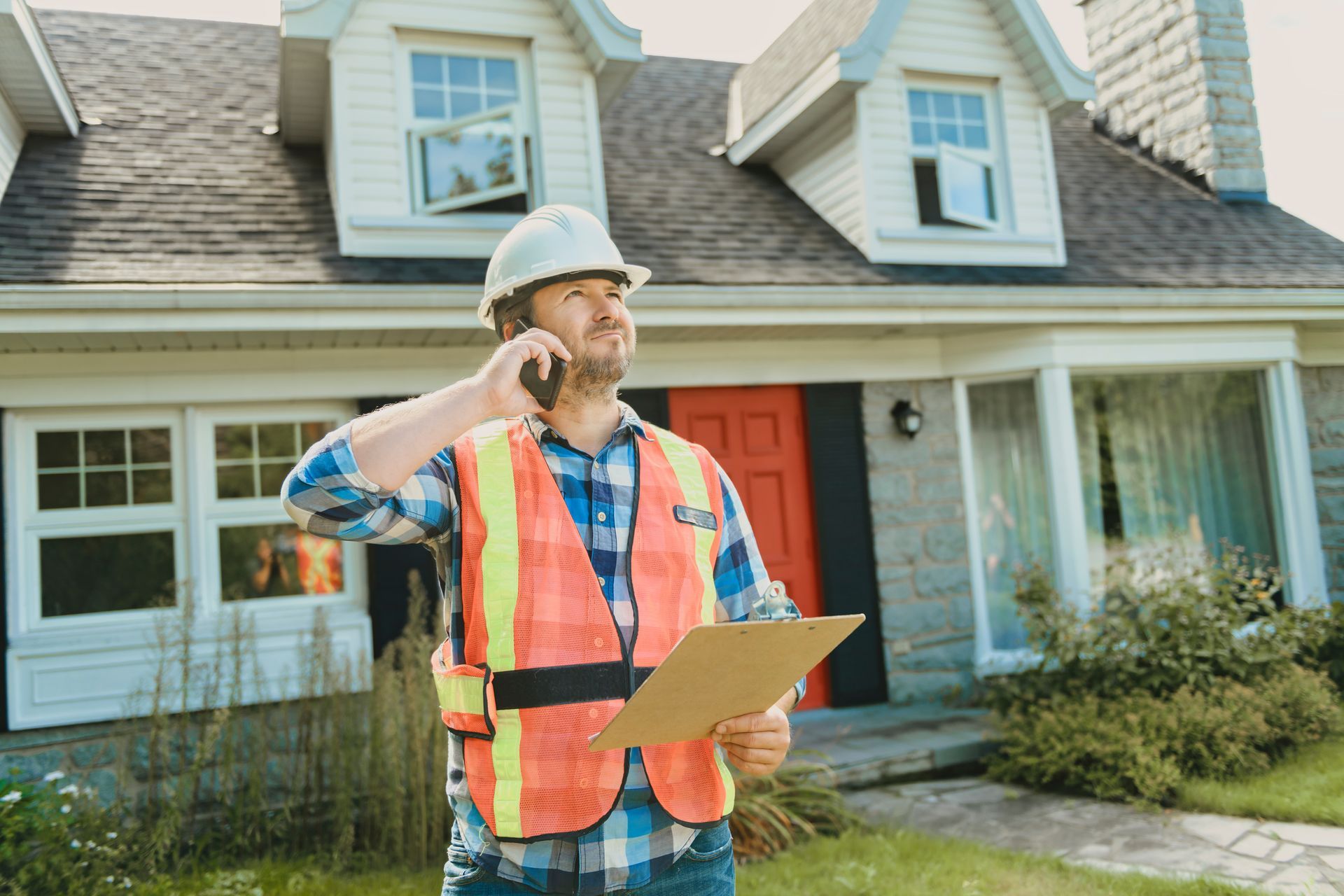 Construction Worker Talking On Phone Outside House Construction Worker Talking On Phone Outside House