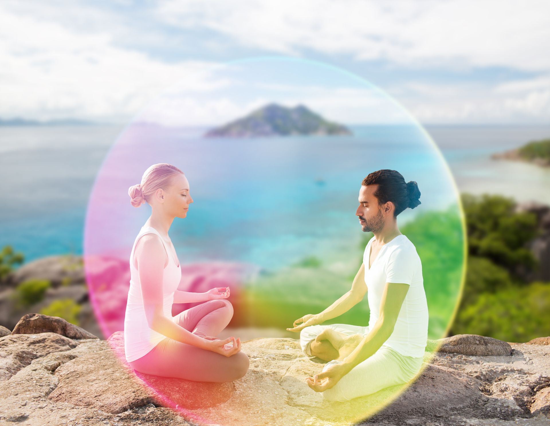 Two people sit in a lotus position on a rocky cliff overlooking the ocean, framed by a glowing, multicolored energy bubble.