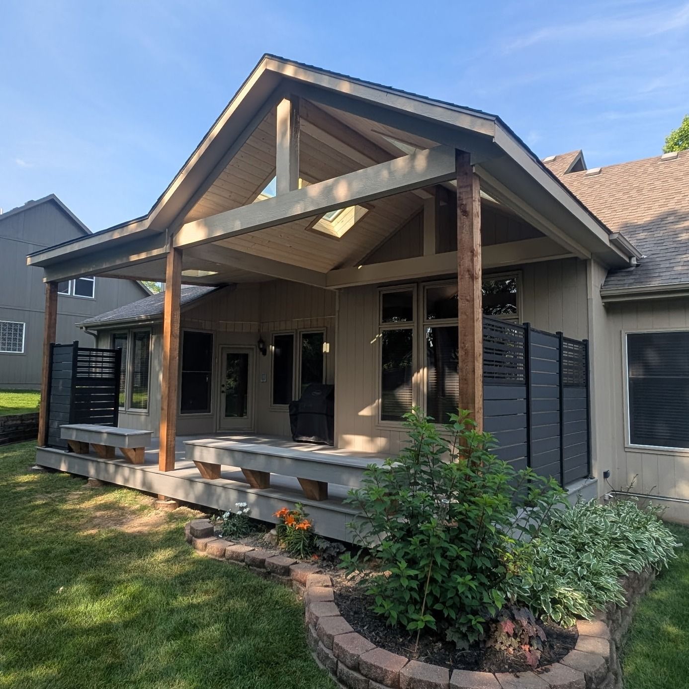 A house with a large porch and a fence in front of it.