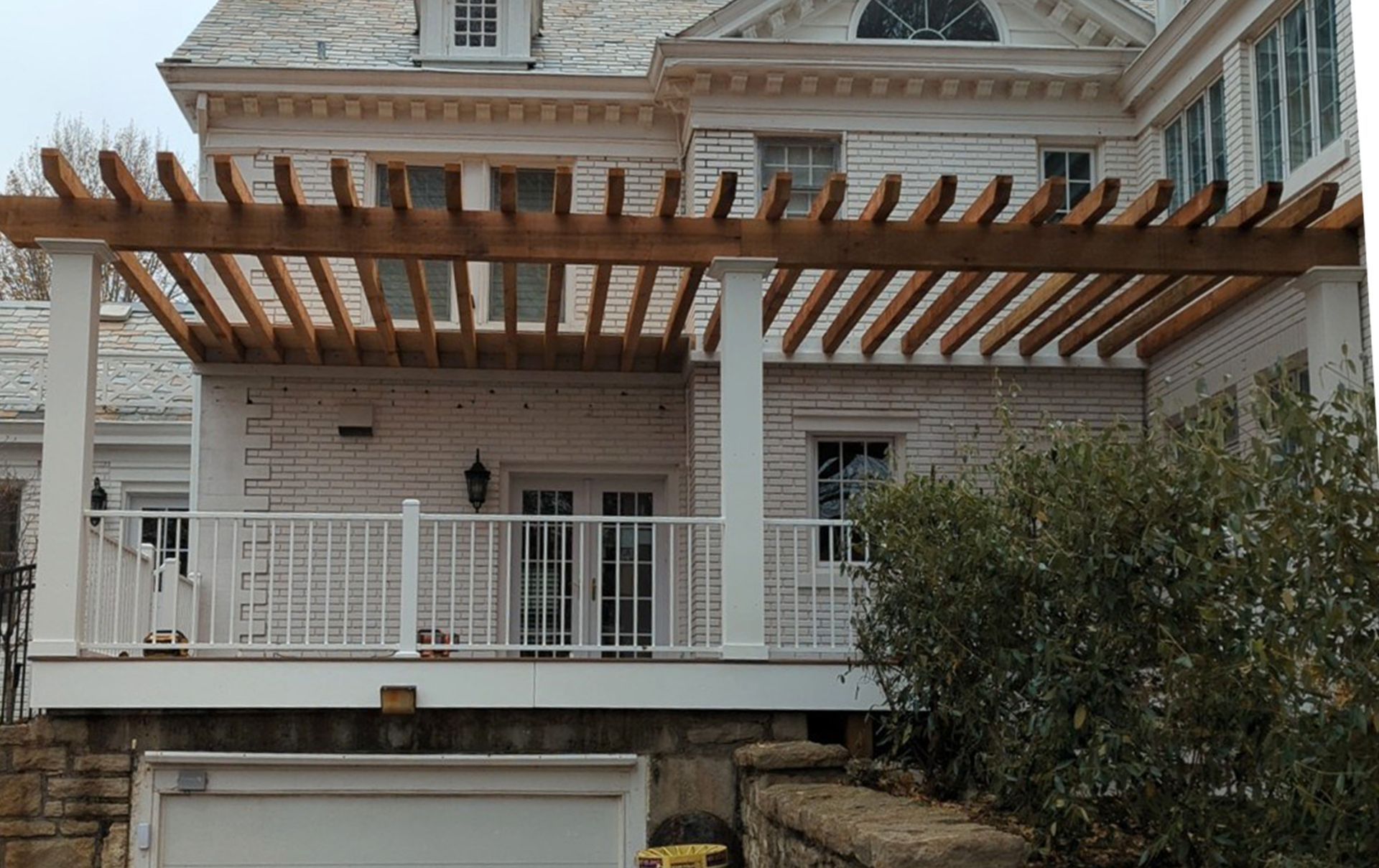 A large white house with a wooden pergola on top of it