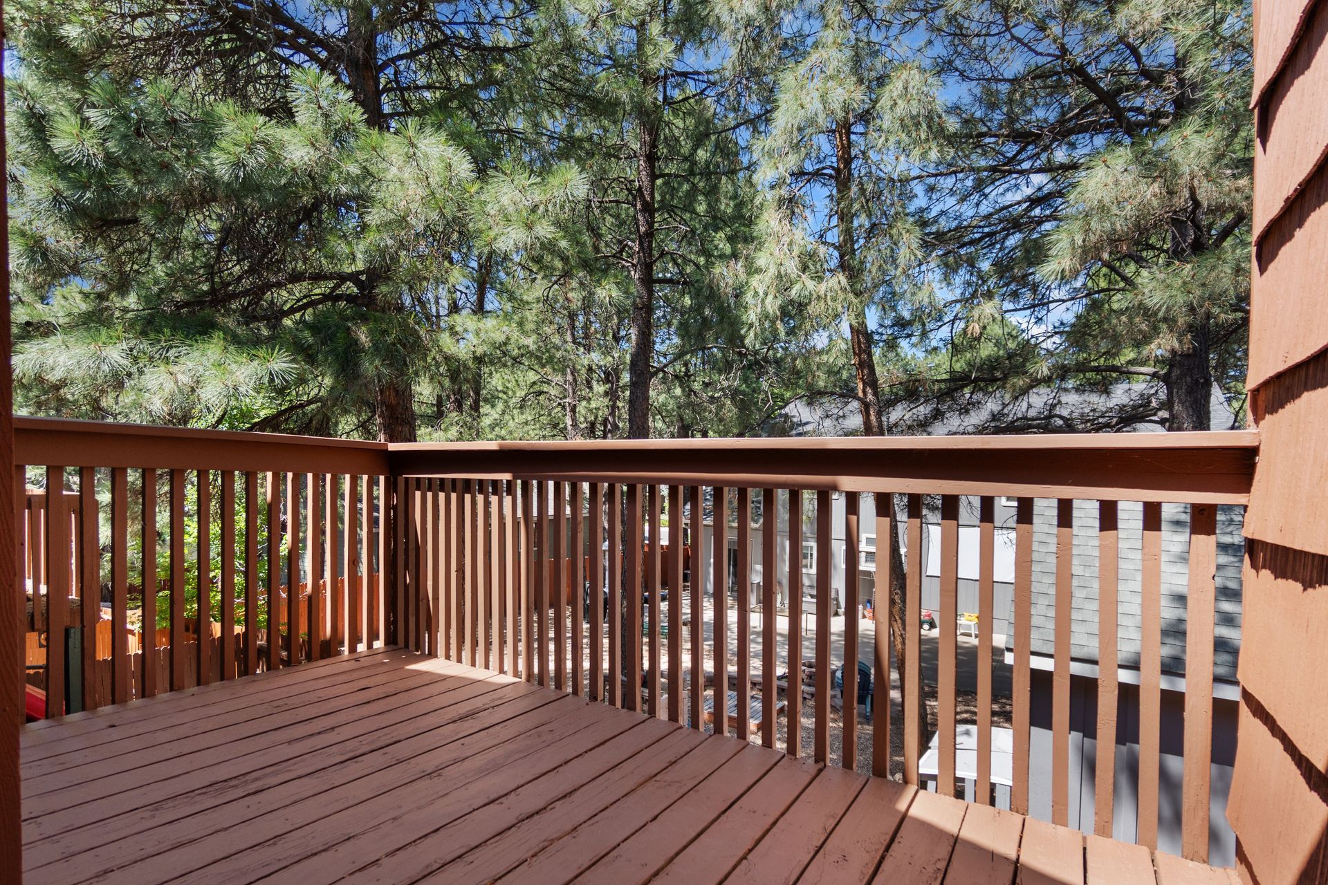A beautiful wooden deck complete with a railing and trees in the background. A beautiful wooden deck complete with a railing and trees in the background.