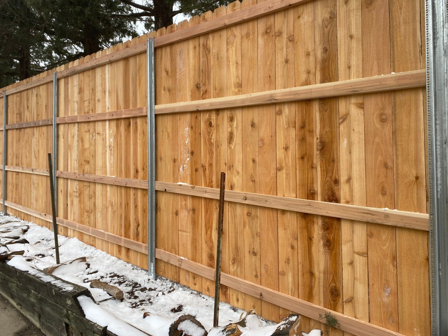 A wooden fence is being built in the snow.