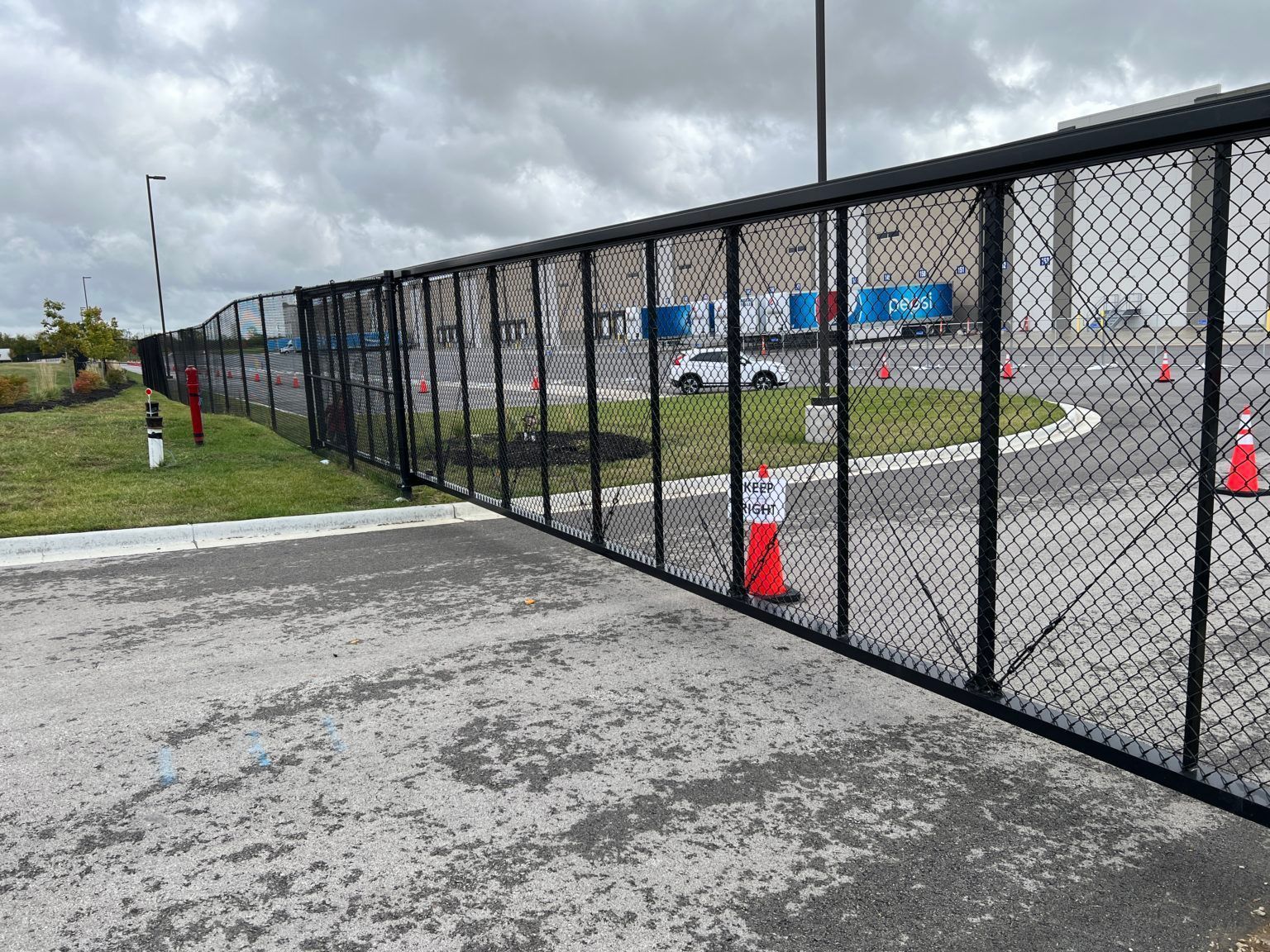 A chain link fence is surrounding a parking lot.