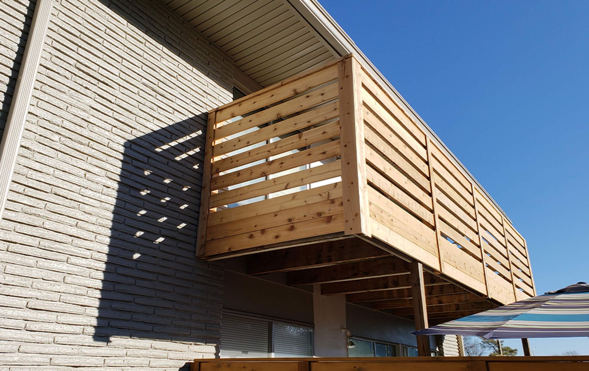 A wooden deck is attached to the side of a house.