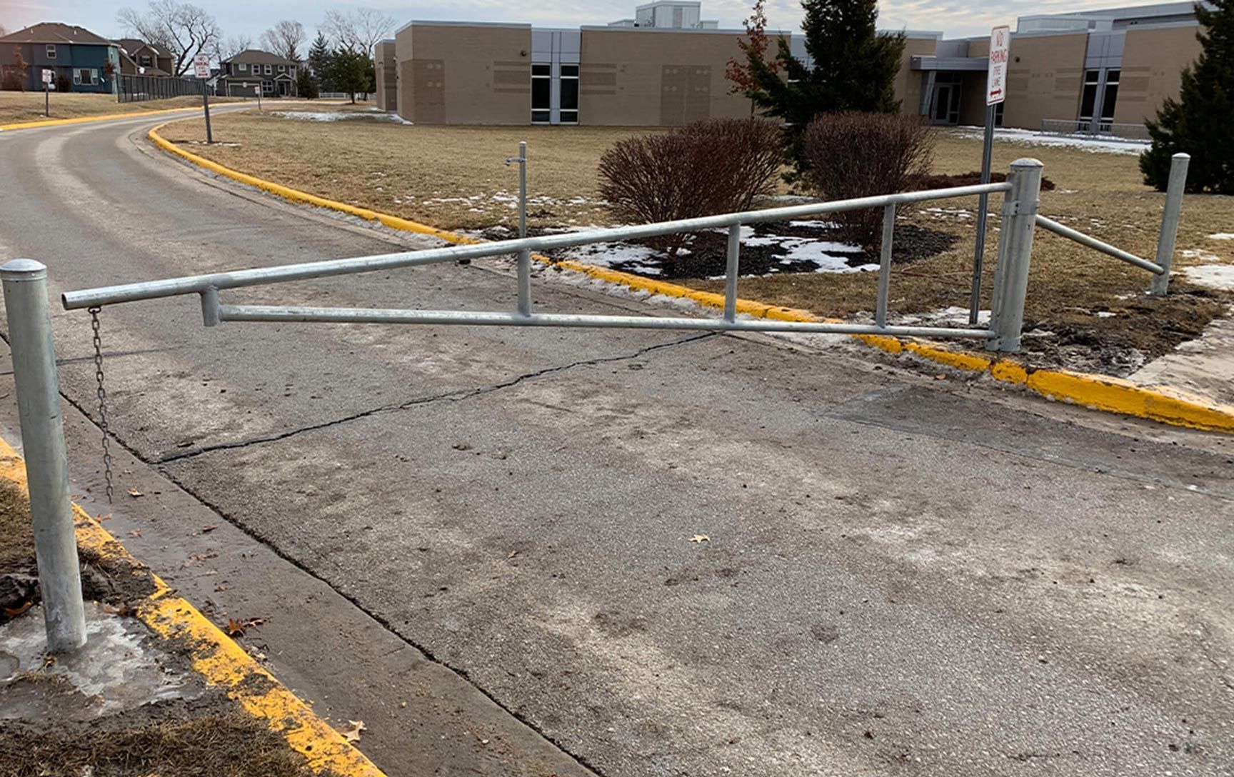A metal gate is sitting on the side of a road.