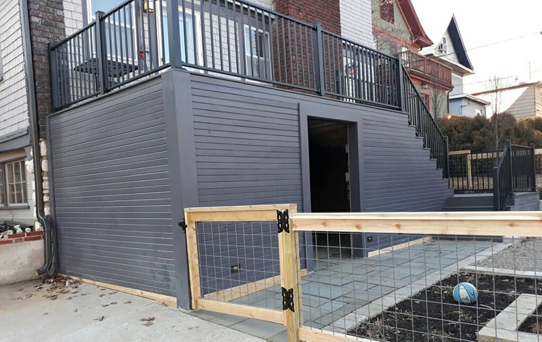 A house with a balcony and a wooden fence in front of it.