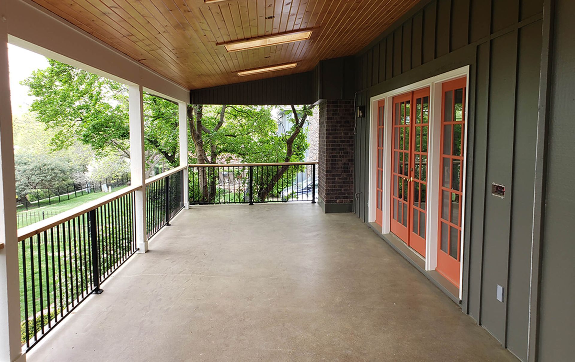 An empty porch with french doors and a railing