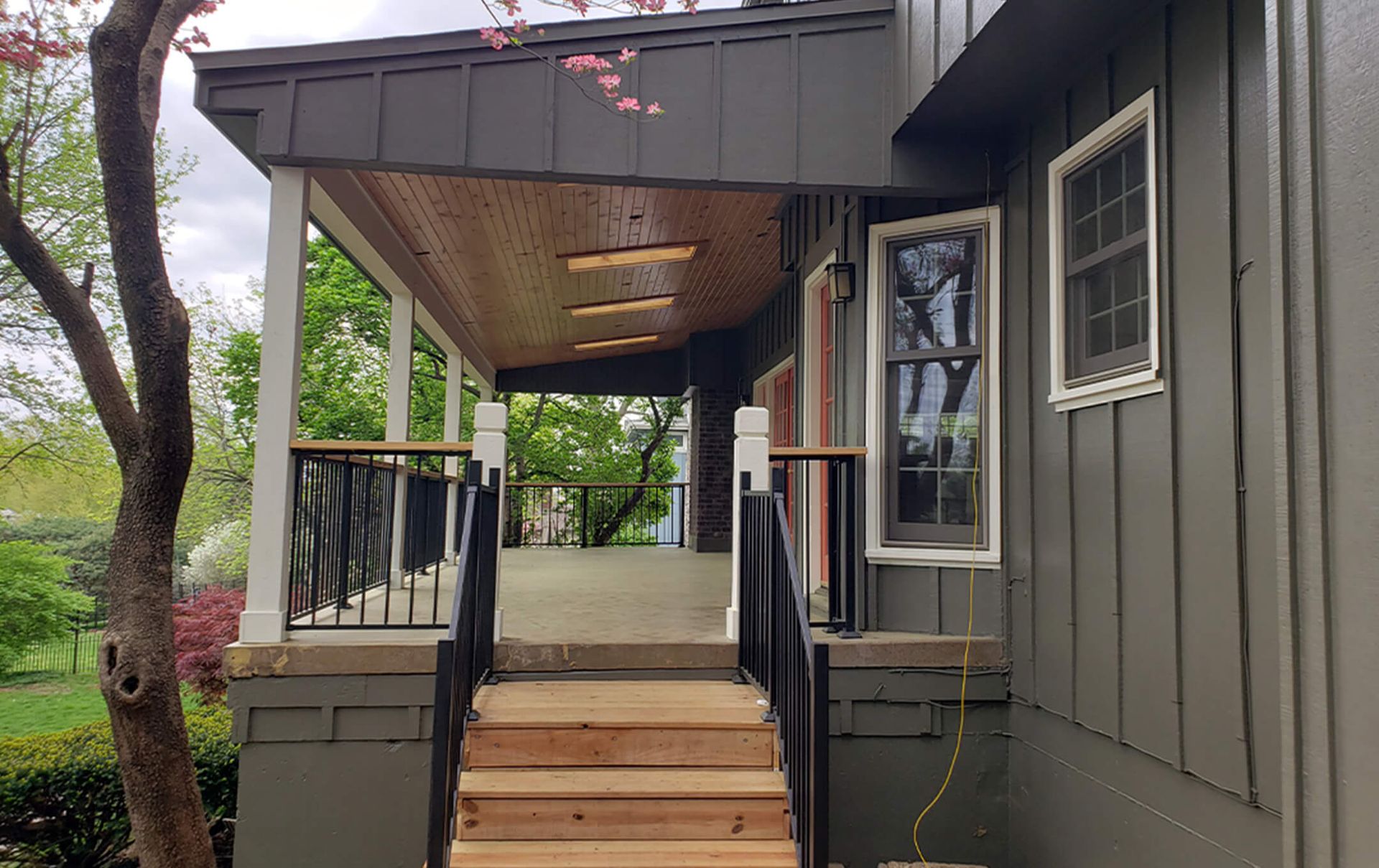A house with a porch and stairs leading to it.