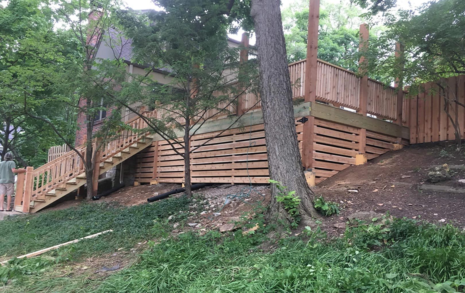 A wooden deck is being built in the backyard of a house.