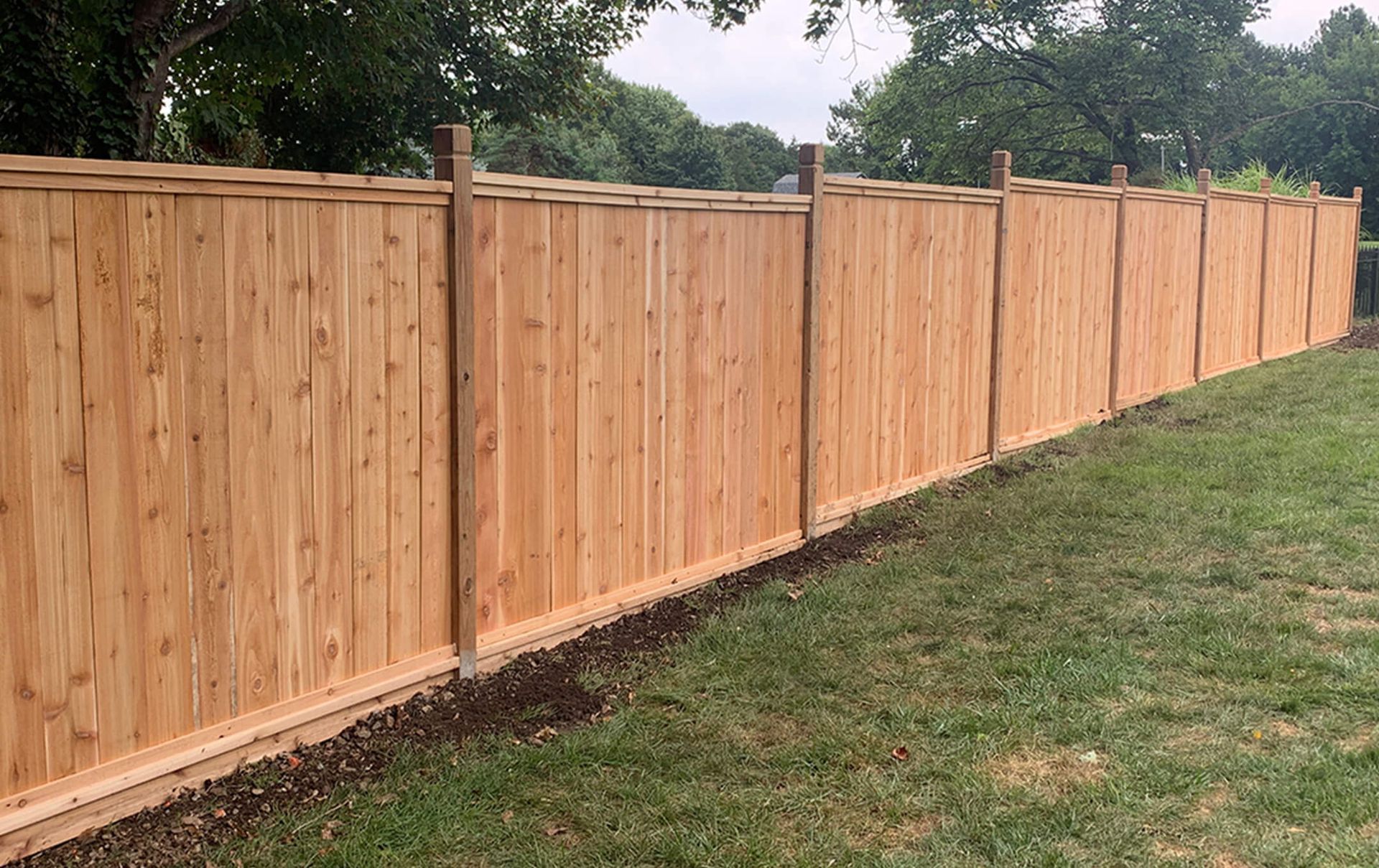 A wooden fence is sitting in the middle of a lush green field.