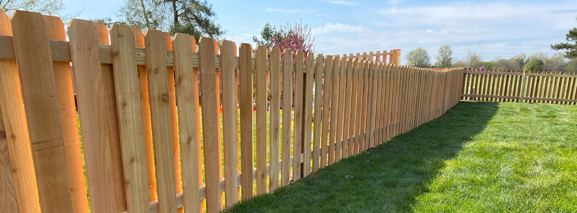 A wooden fence is sitting in the middle of a lush green field.