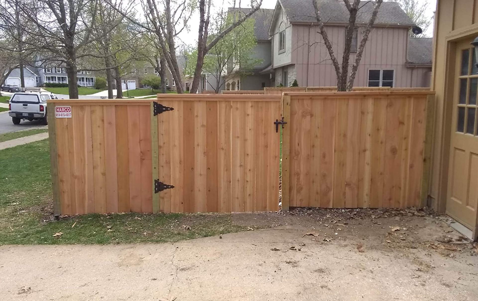 A wooden fence with a gate in front of a house