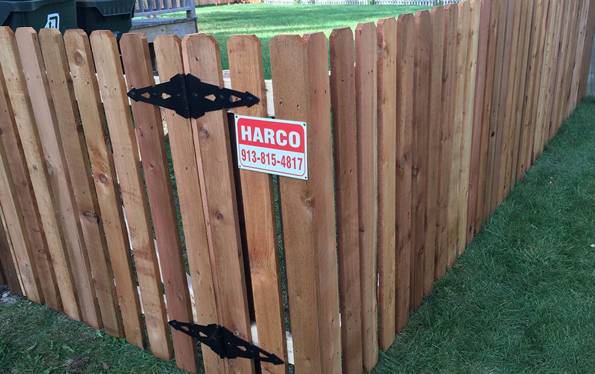 A wooden fence with a sign that says marco on it.