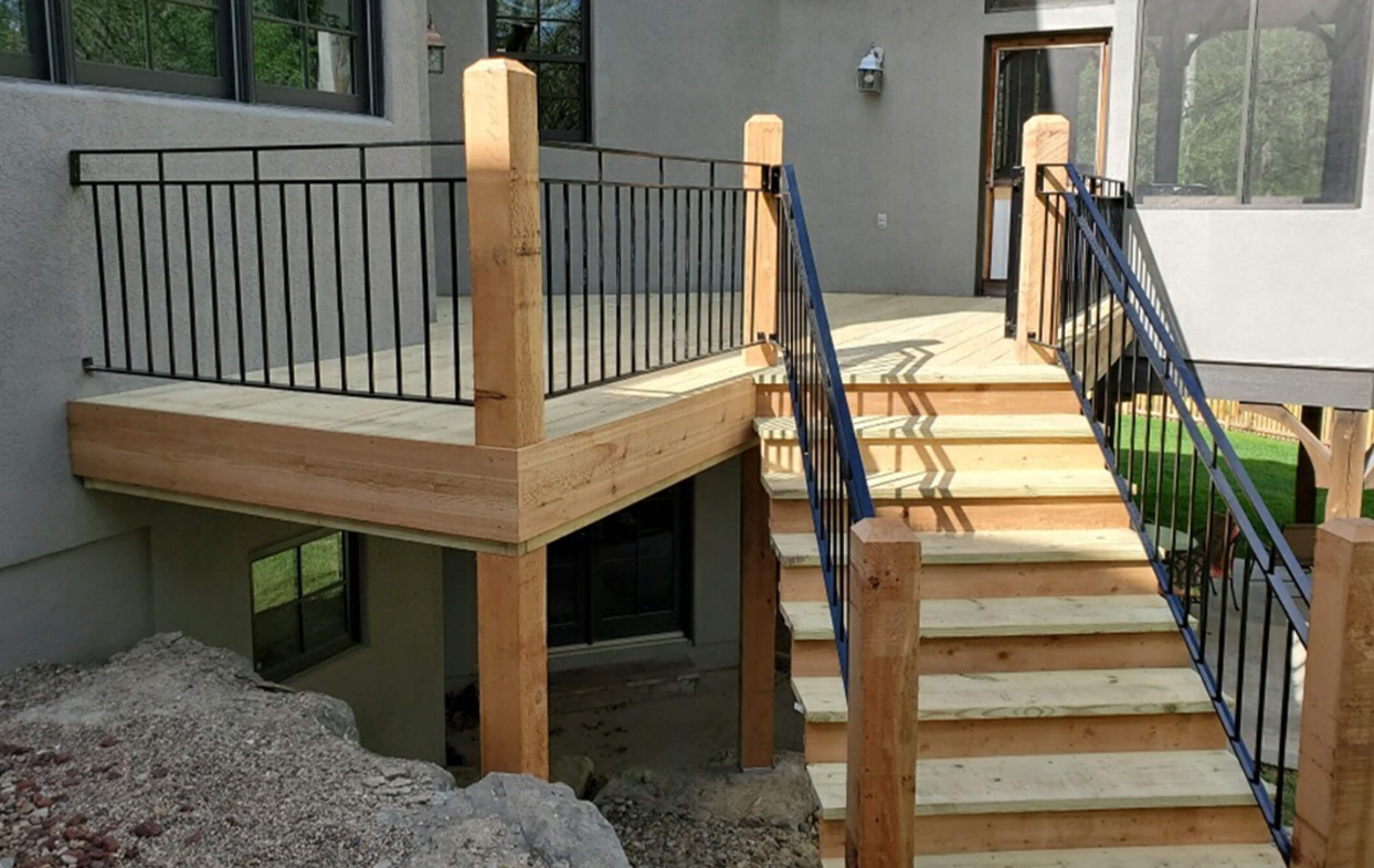 A close up of a wooden deck next to a concrete floor.