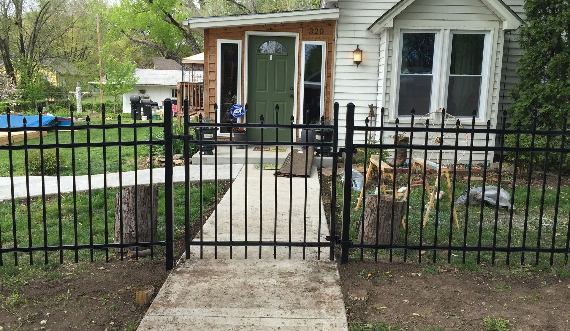 A close up of a wrought iron fence in front of a house.