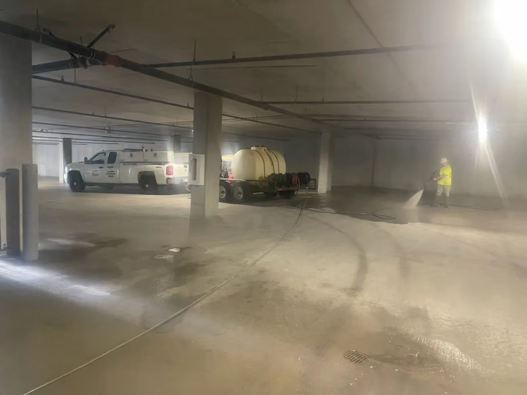 Dusty indoor parking garage with a white van and a person in a yellow jacket near the far wall
