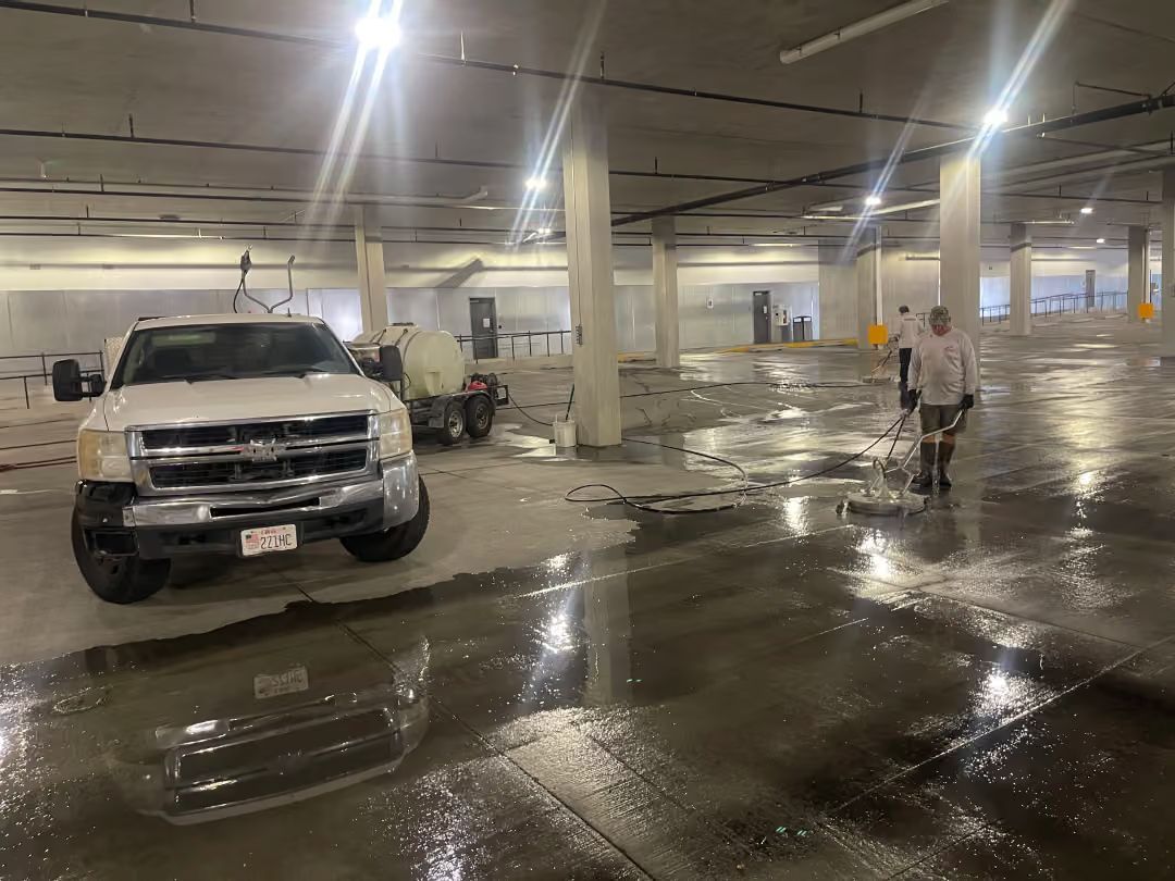 Flooded parking garage with a white pickup truck and a person standing near wet reflections.