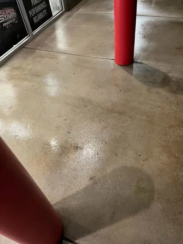 Wet concrete floor with red columns and reflections indoors