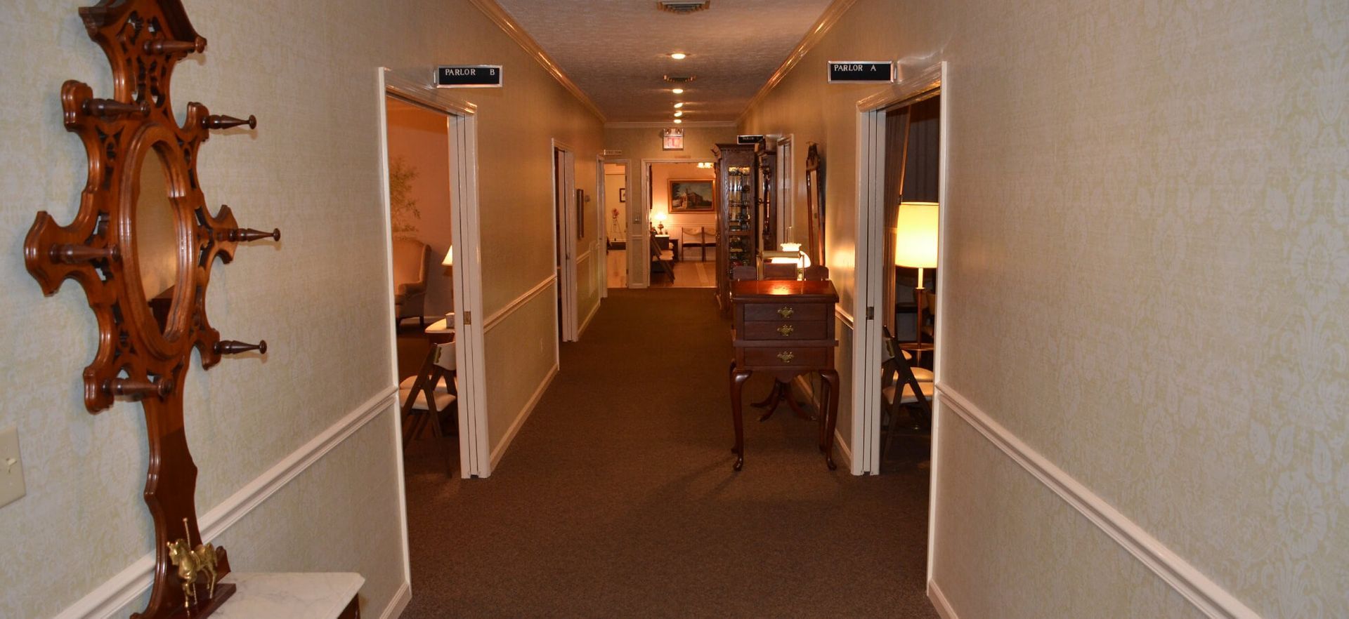 A long hallway in a hotel with a mirror on the wall.