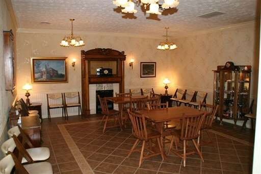 A room with tables and chairs and a fireplace
