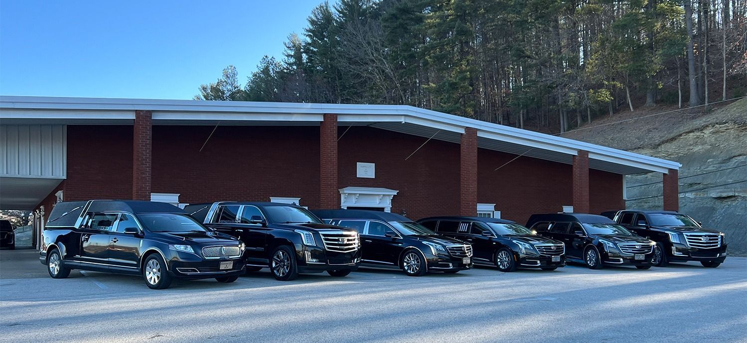 A row of cars are parked in front of a building