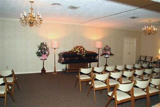 A room with chairs and a coffin in it