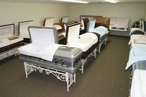 A room filled with lots of coffins including a silver coffin