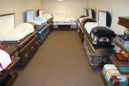 A row of coffins are lined up in a room.
