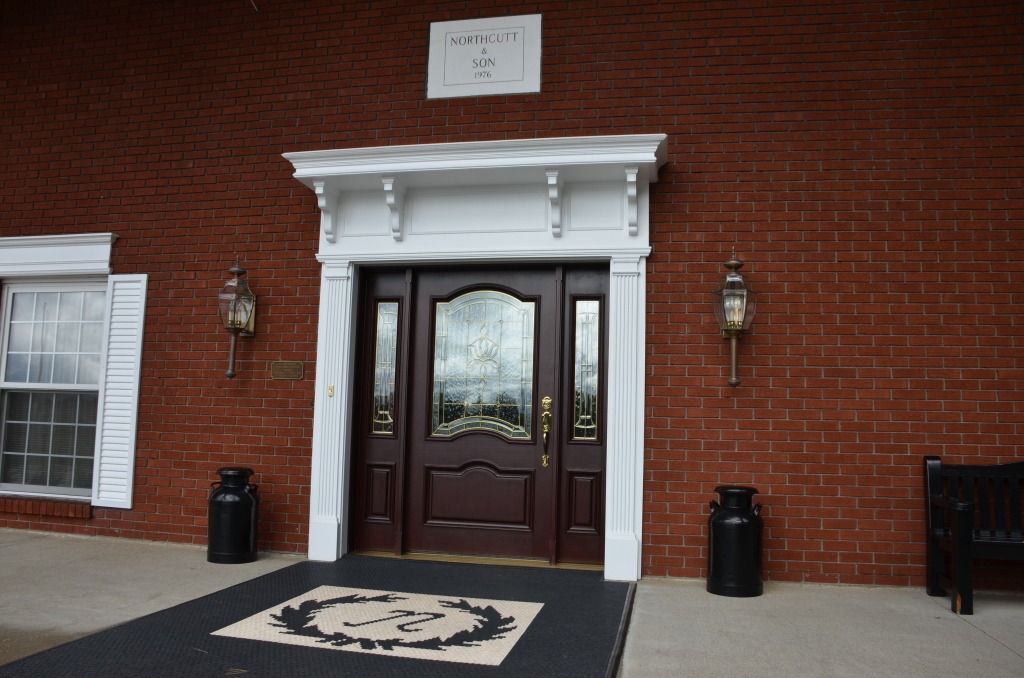 A brick building with a brown door and a white trim