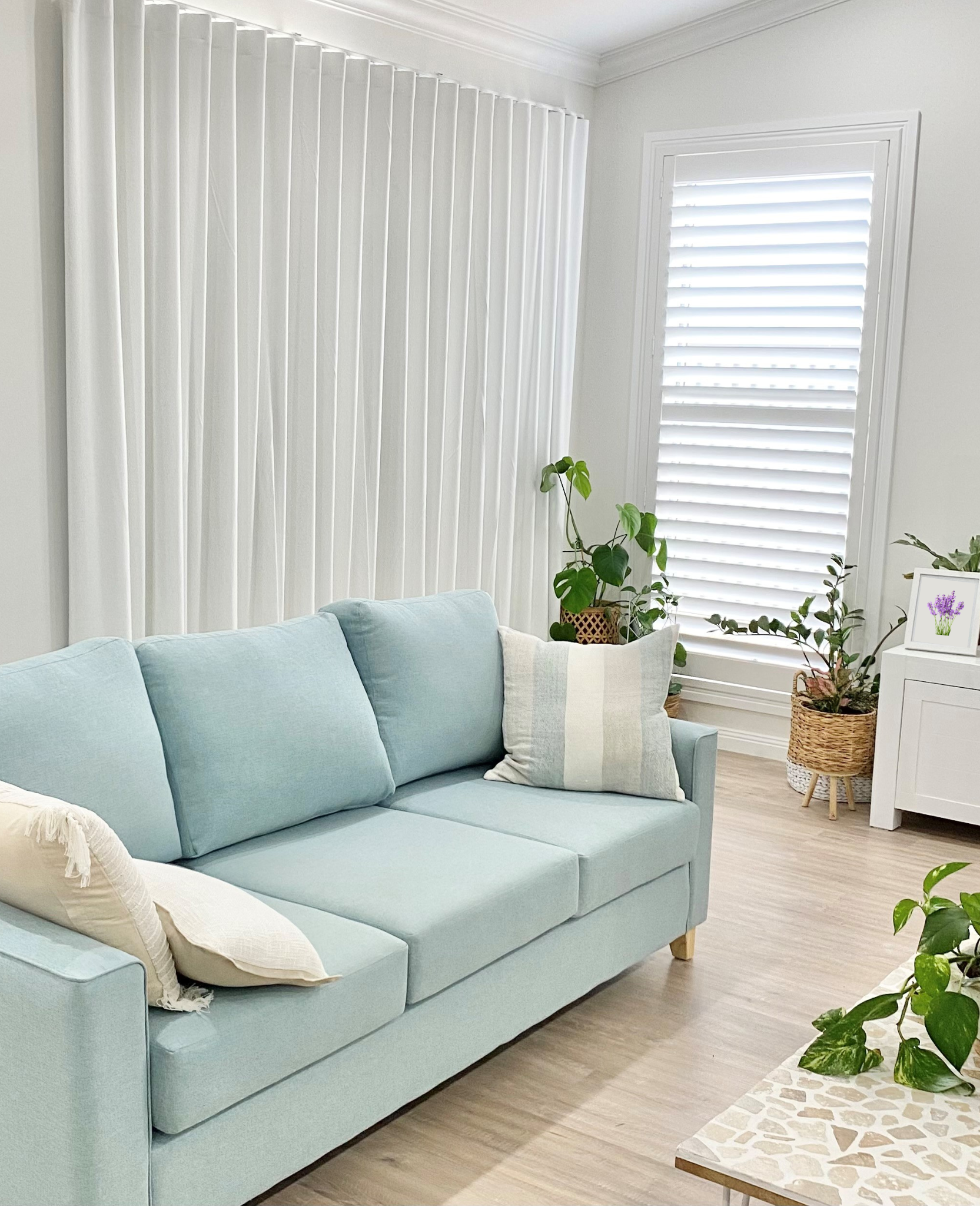 White block out curtains and white PVC shutters in a modern loungeroom