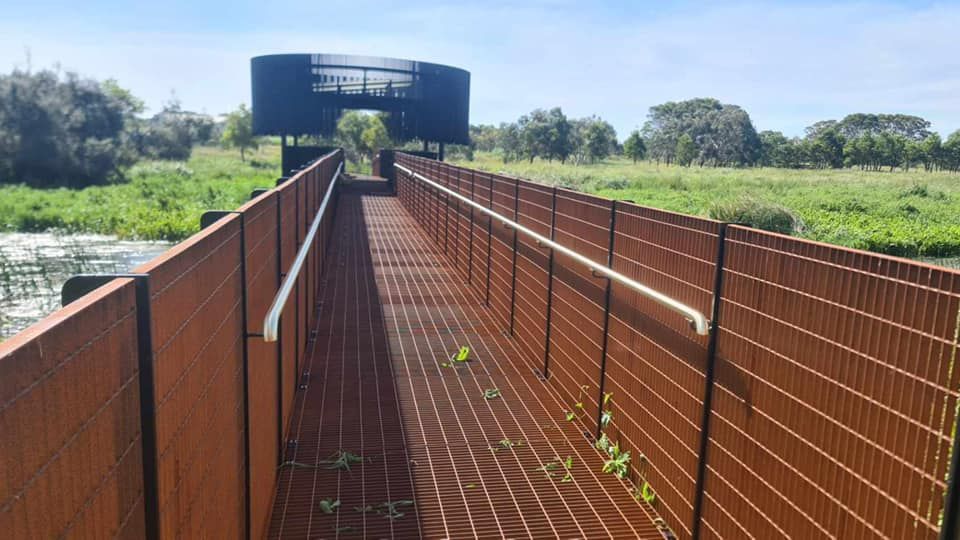 A bridge over a body of water with a fence surrounding it.