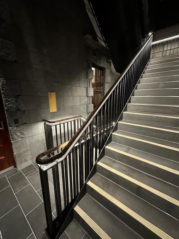 A staircase with a railing and a door in the background.
